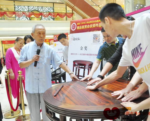 故宫家具修复专家、古典家具传承工艺大师王秀林请消费者通过触摸感受《大红酸枝·明式枕环月牙桌》的精湛工艺 故宫家具修复专家、古典家具传承工艺大师王秀林请消费者通过触摸感受《大红酸枝·明式枕环月牙桌》的精湛工艺