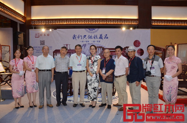 轩禾殿红木营销经理向艺（左六）与全联民间文物艺术品商会会长宋建文（左四），原故宫博物院文保科技部主任曹静楼（左五），中国高等家具设计专业创始人、中南林业科技大学博士生导师胡景初（右五），《红木家具通用技术条件》标准主要起草人之一曹新民（左三），华南农业大学教授李凯夫（右二），家具行业资深媒体人王周（右三），全联艺术红木家具专委会执行会长林伟华（右四）一行在轩禾殿红木展示区前合影留念