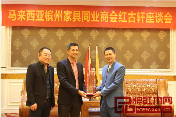 马来西亚槟州家具同业商会署理会长龚伟杰赠予红古轩总经理吴赤宇马来西亚的优秀设计作品“巨椅”