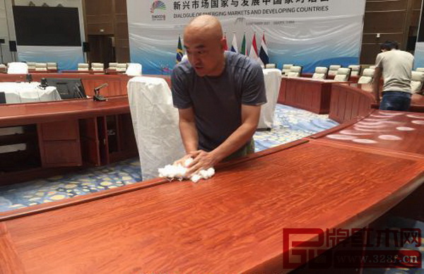 会议现场工作人员在擦拭红木家具 会议现场工作人员在擦拭红木家具