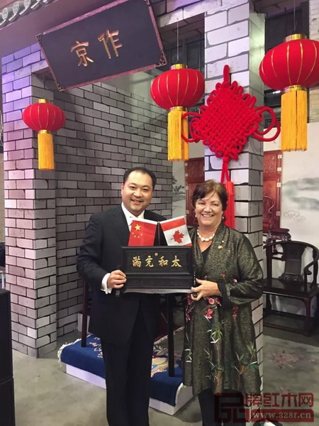 太和木作董事长关毅先生（左）向加拿大前副总理希拉·科普斯女士赠送“太和充满”故宫微型匾额