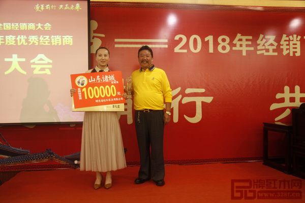  在明清居2017优秀经销商表彰大会上，董事长金彪云（右）为获奖经销商颁奖