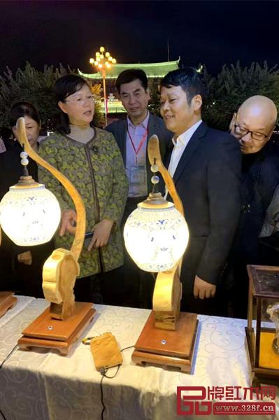 江西省上饶市副市长郑少微(左二)盛赞刘孝樟的木雕技艺 江西省上饶市副市长郑少微(左二)盛赞刘孝樟的木雕技艺