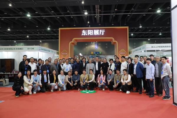 参展东阳红木企业负责人在东阳展厅面前合照